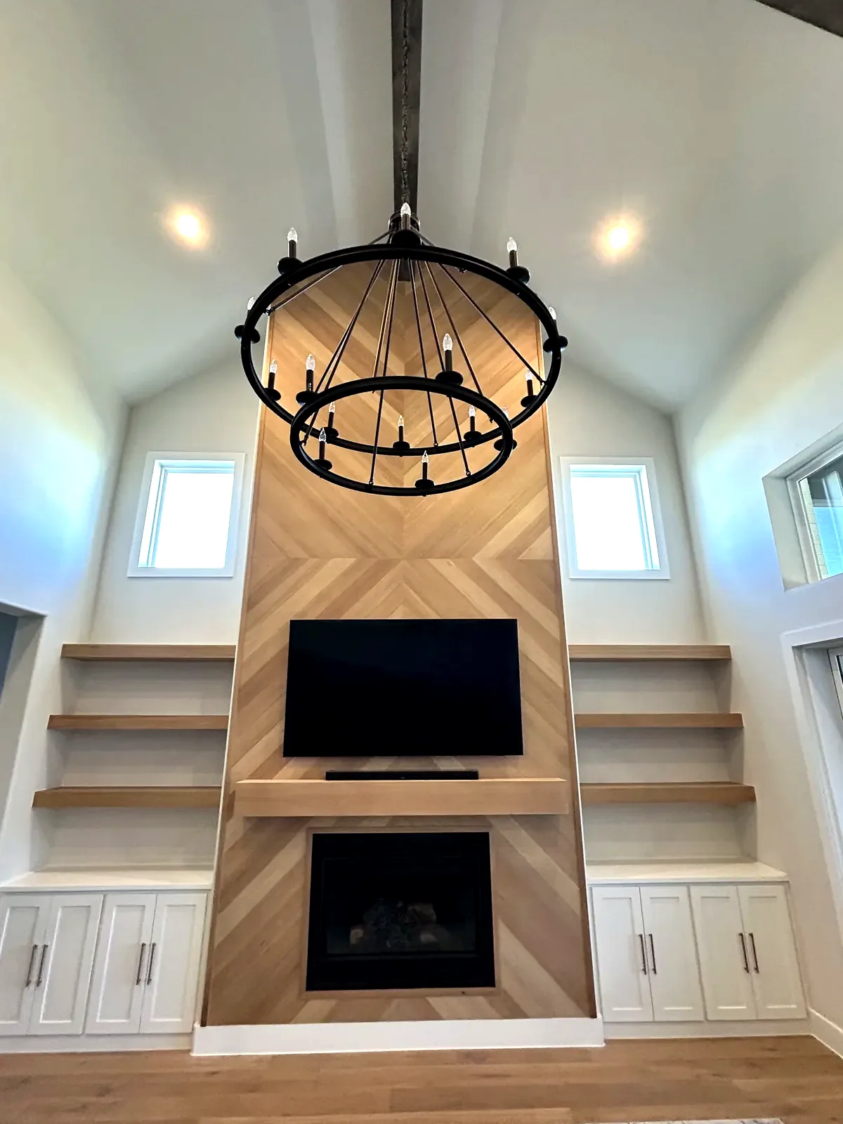 Floor-to-ceiling chevron white oak feature wall with built-ins.