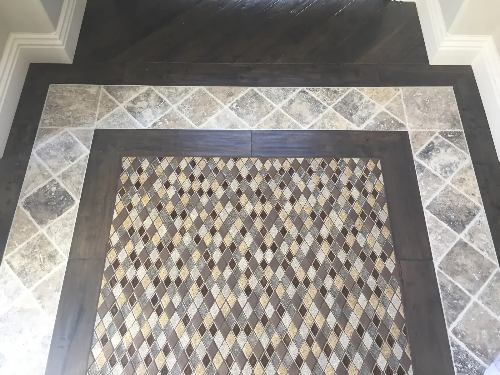 Tile border inlay set into hardwood entry — a real detail from a recent project.